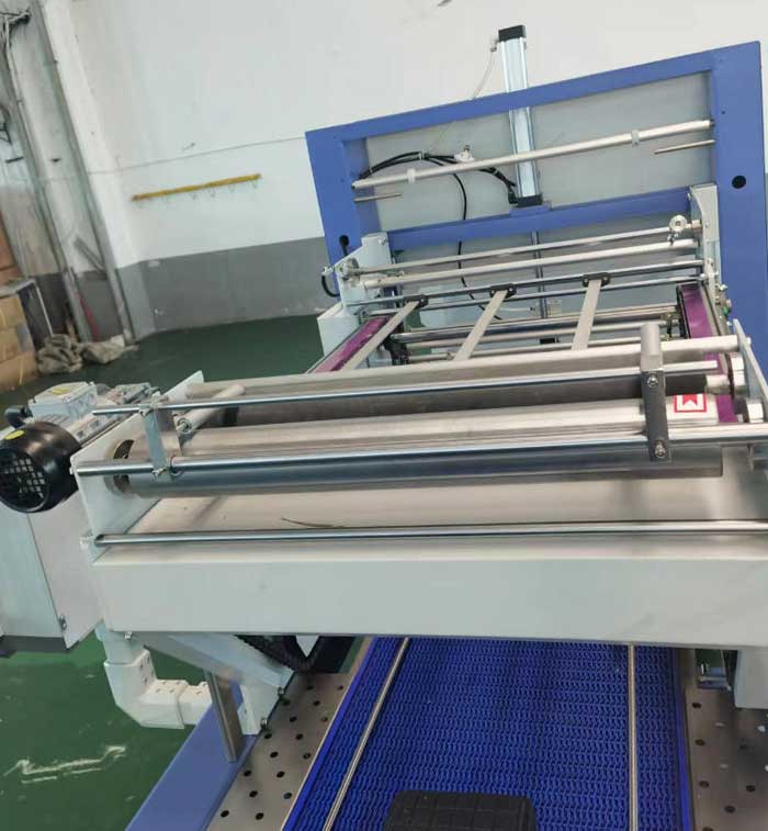 Delivery of film for linear shrink packing machine
